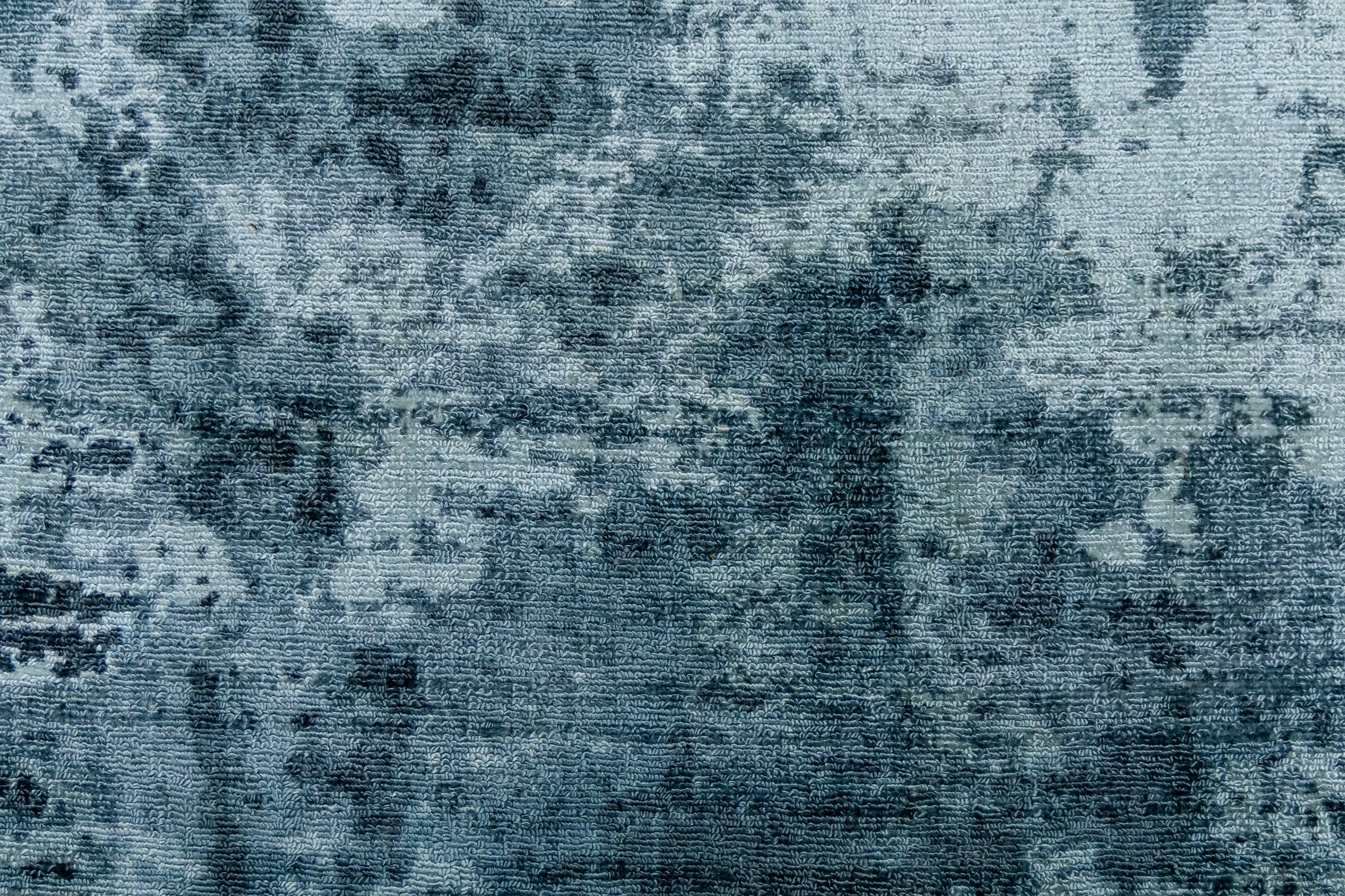 Detail shot of Blue Textured Hand-Loom Printed Viscose Handmade Rug for bed rooms, offices, and dining spaces.