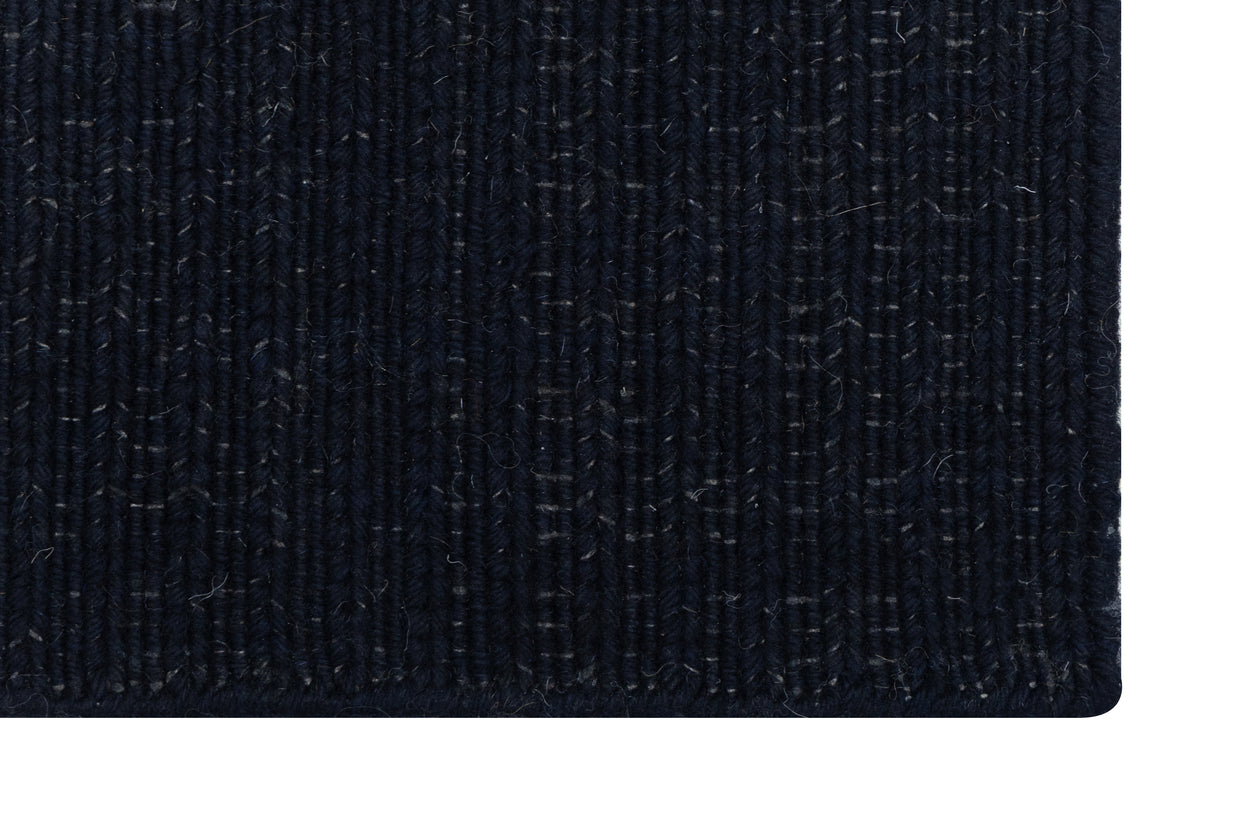 Close-up of Solid Black Texture Hand-Woven Soumak woolen rug for bed rooms, offices, and dining spaces. 