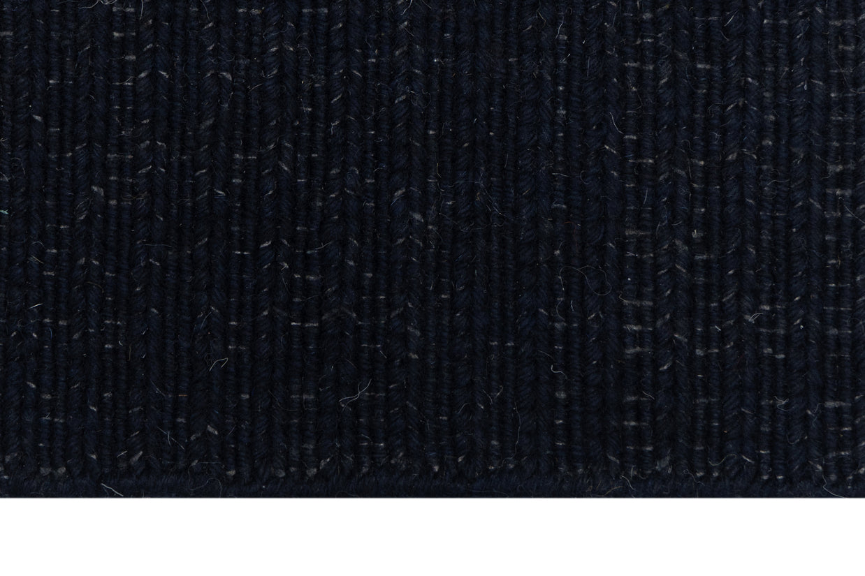 Close-up of Solid Black Texture Hand-Woven Soumak woolen rug for bed rooms, offices, and dining spaces. 