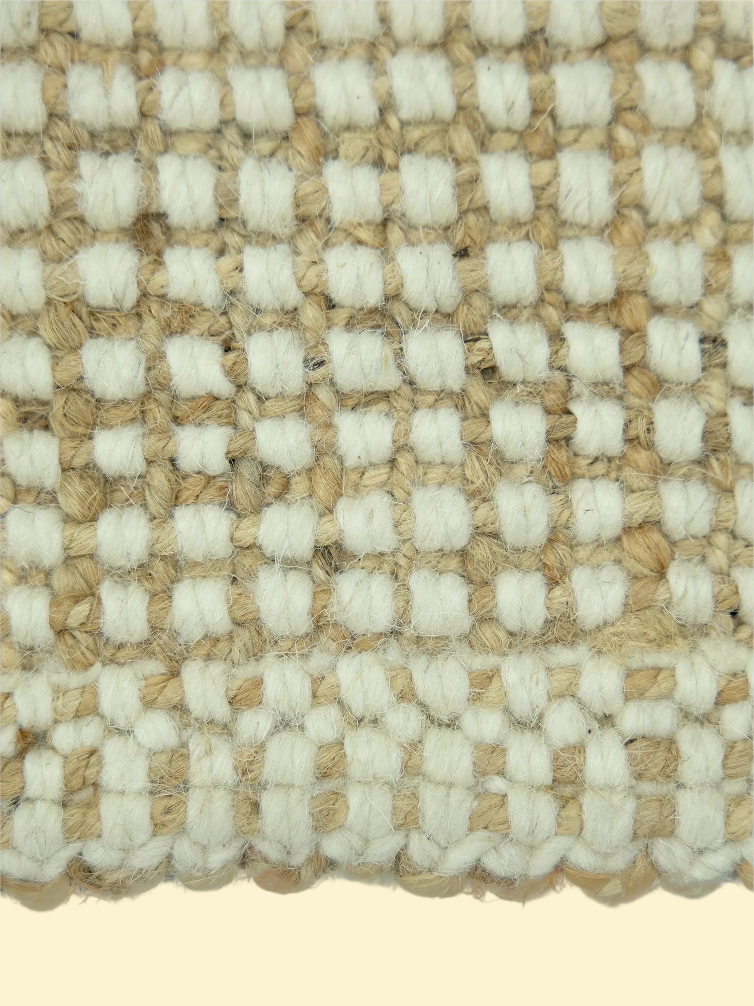 Alpine Grid Handwoven Pitloom Rug, Close-up of a woven pattern jute and wool rug with alternating beige and white squares.