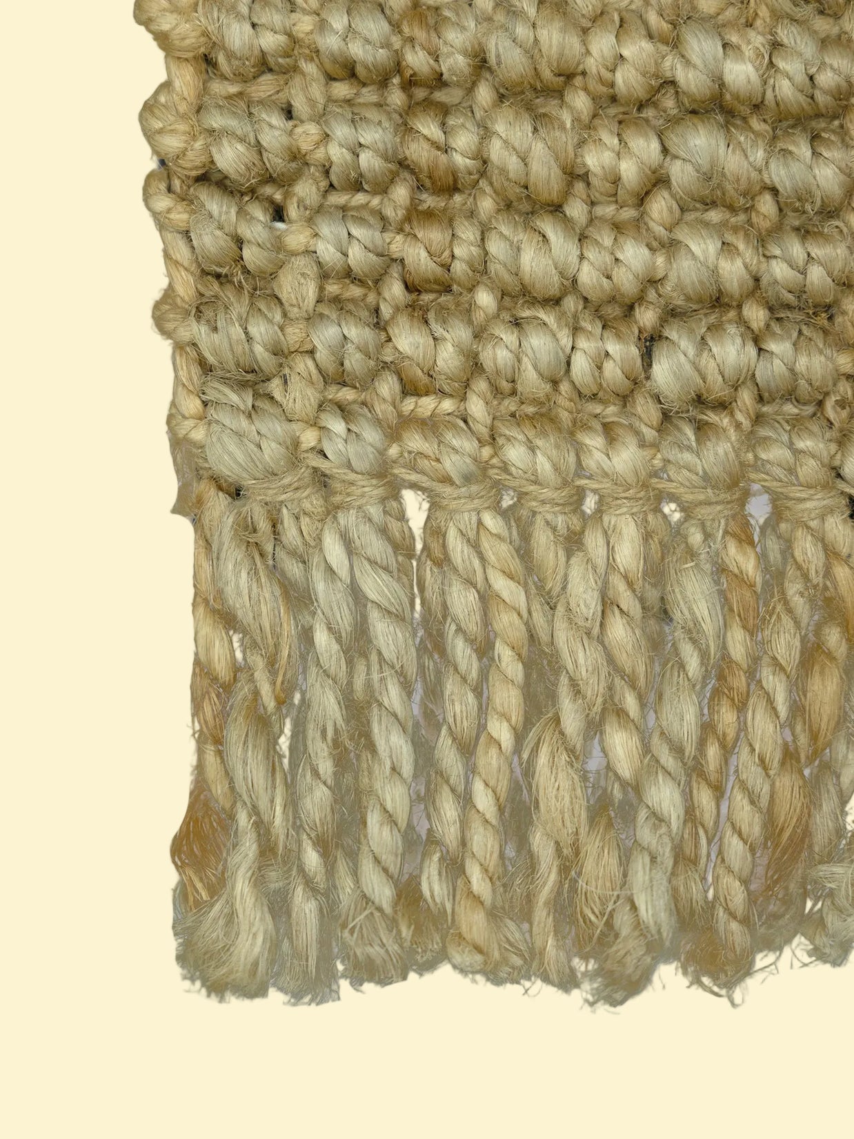 Desert Loom | Handwoven Pitloom Durrie, Close-up of a textured beige jute fabric with braided trim