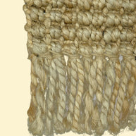 Desert Loom | Handwoven Pitloom Durrie, Close-up of a textured beige jute fabric with braided trim