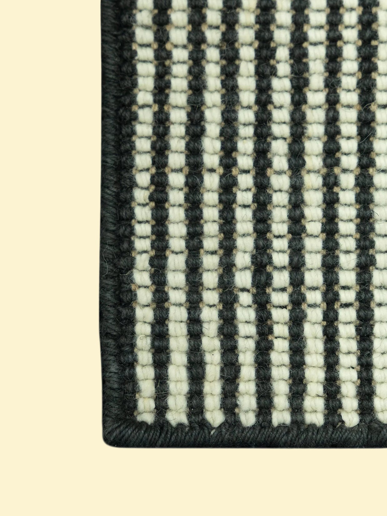 Close-up of a black and white striped woven pattern of jute and wool rug