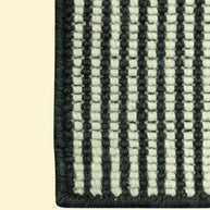 Close-up of a black and white striped woven pattern of jute and wool rug