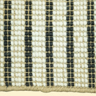Close-up of a woven jute and wool with black, white, and beige stripes on a white background