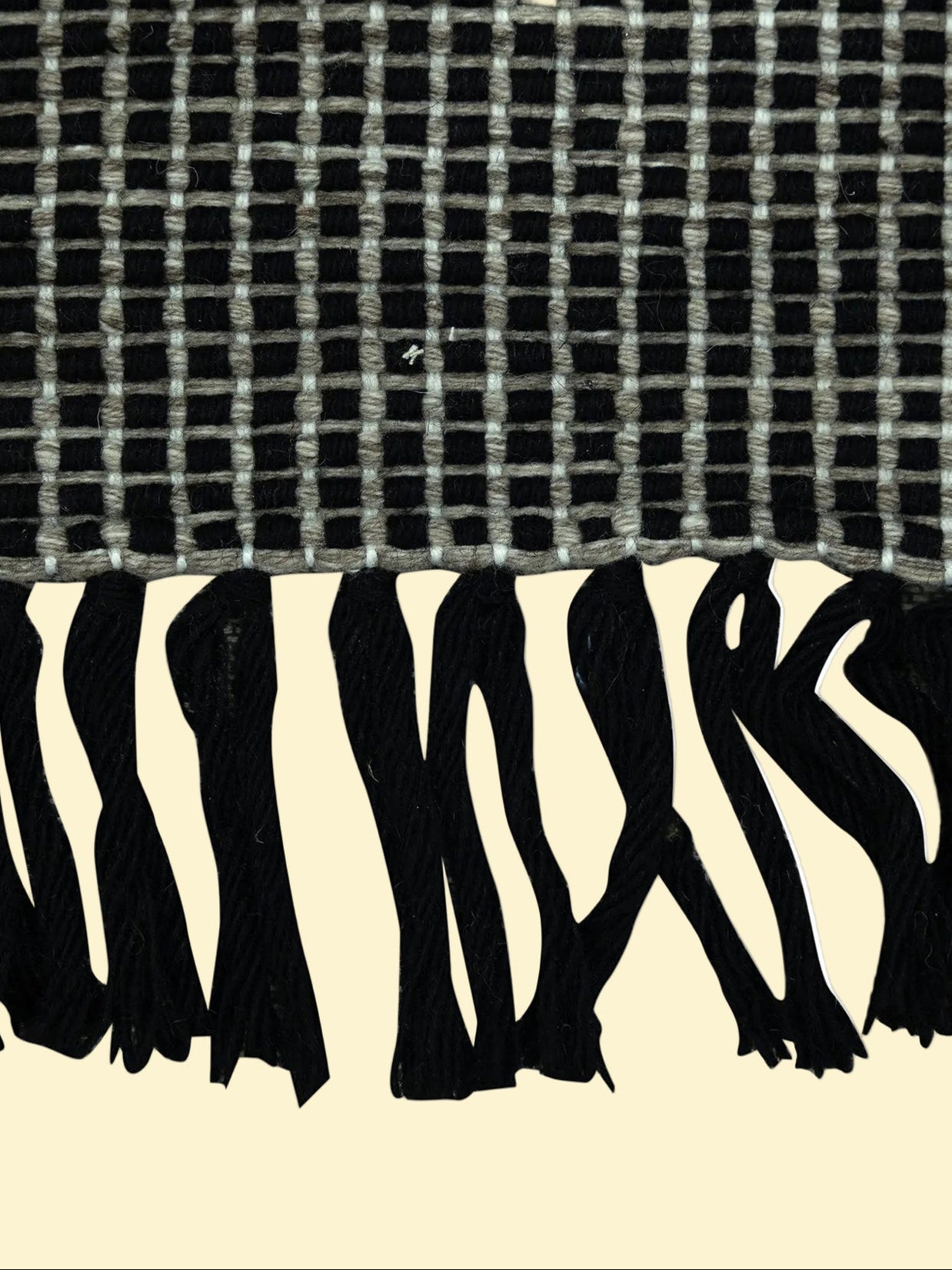 Outdoor_Handwoven_Pitloom_Durrie_Corner, Textured black and white fabric with a checkered pattern above and zebra print below.