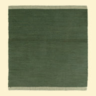 Green woven cotton durrie with a natural  beige border