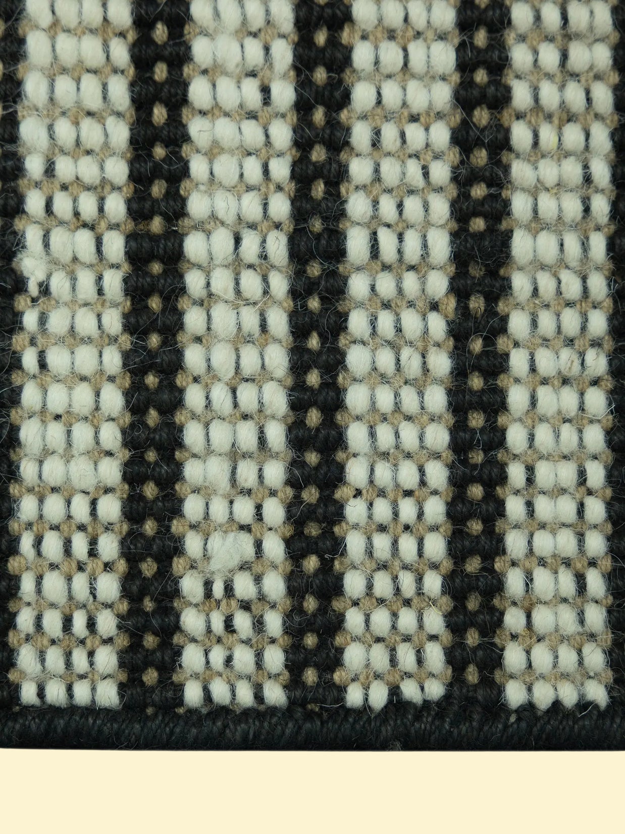 Pitloom Handwoven Wool Jute Rug Detail, Close-up of a woven pattern with black, white, and beige colors.