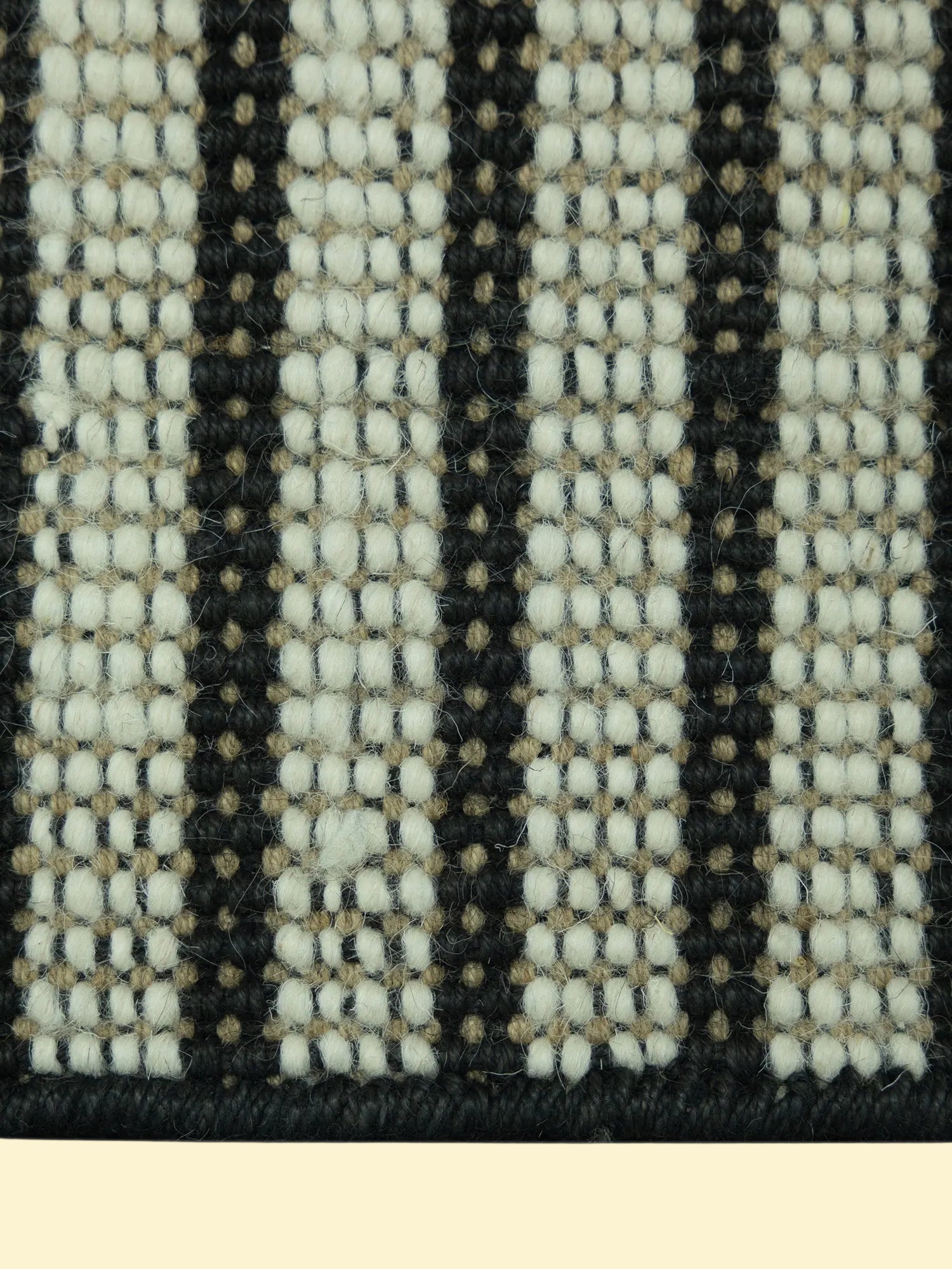 Pitloom Handwoven Wool Jute Rug Detail, Close-up of a woven pattern with black, white, and beige colors.